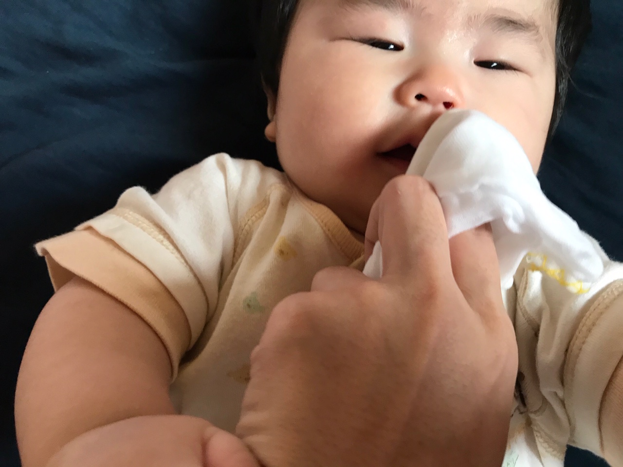 赤ちゃんの顔をガーゼで拭く